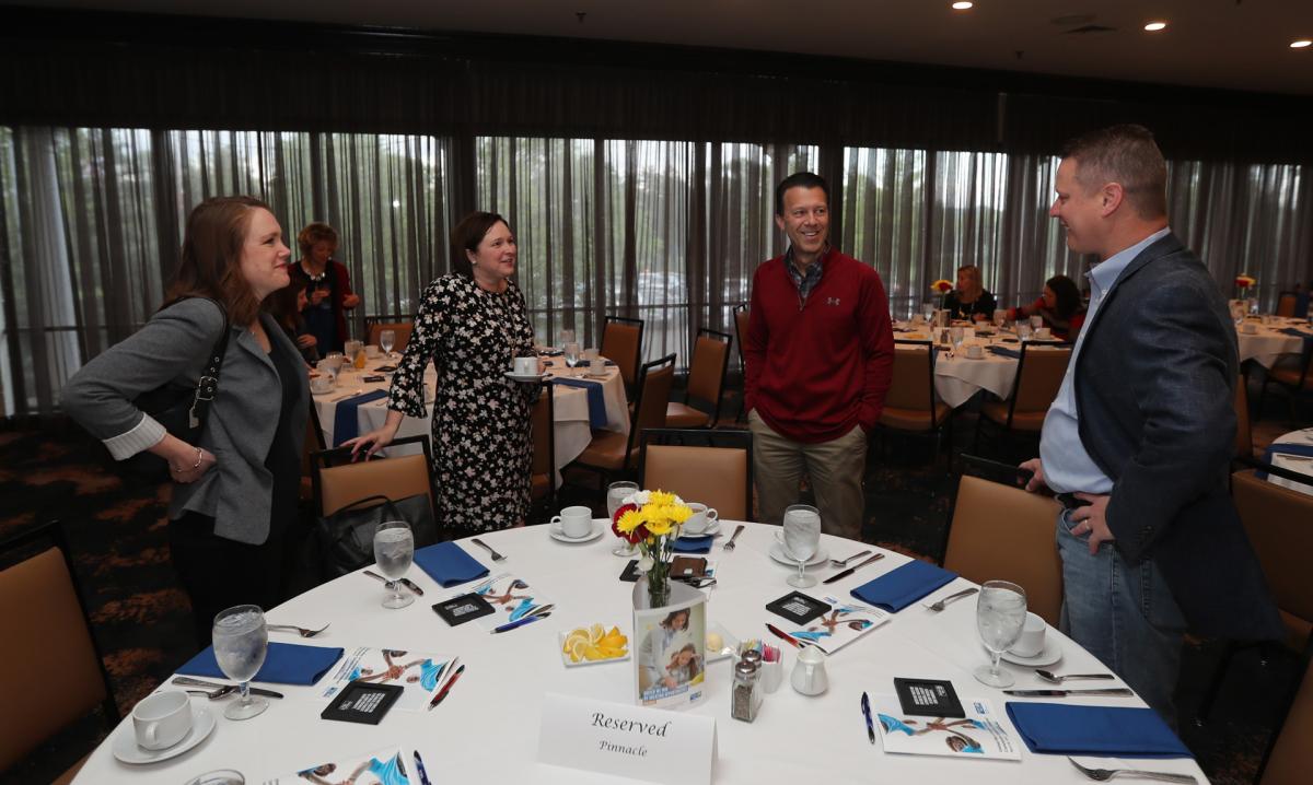 Guests from event sponsor Pinnacle Financial chat before the start of the Celebration Breakfast at Bluegrass Country Club.