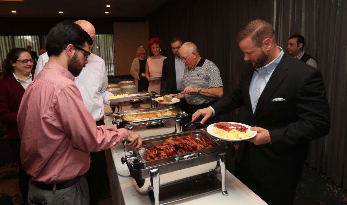 Former UWSC Board Member Justin Fontenot from ServisFirst Bank leads guests through the buffet line at the annual Community Celebration Breakfast.