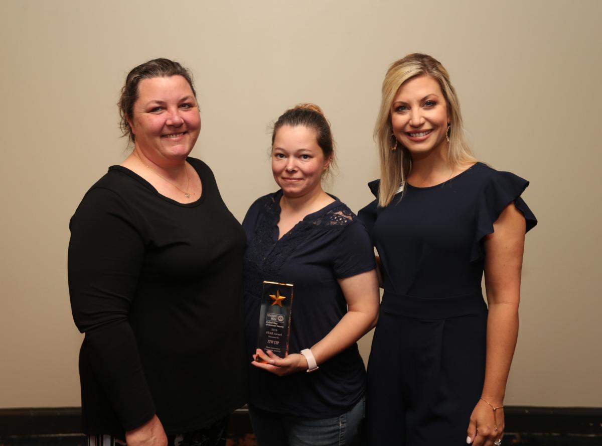 Amie Davenport and April Wanner from ITW CIP accept the award for Most Innovative Campaign Event from UWSC Cheif Development Officer Erin Birch. ITW CIP earned the recognition for promoting UWSC at its company booth during last fall's Gallatin Main Street Festival.