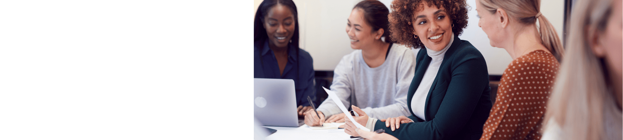 employees talking while holding a paper and looking at a computer