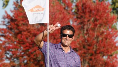 golfer holding ball by Servpro sponsor flag