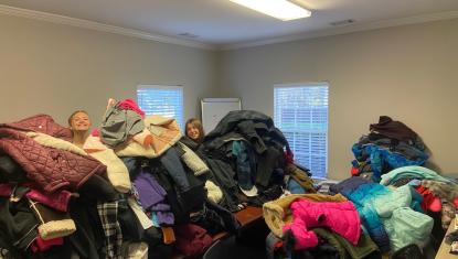volunteers behind pile of coats