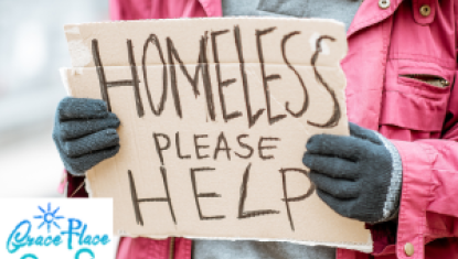 lady in coat and gloves holding homeless sign